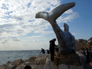 Рыбаки рядом со скульптурой "дырявого" кита в Акко.