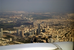 Под крылом самолета - небоскребы Тель-Авива. Черная круглая башня - самое высокое и дорогое здание Израиля -башня Моше Авив. Правее, у самой кромки крыла - верхушки комплекса трех высотных зданий - квадратного, круглого и треугольного. Это - Азриэли-центр.